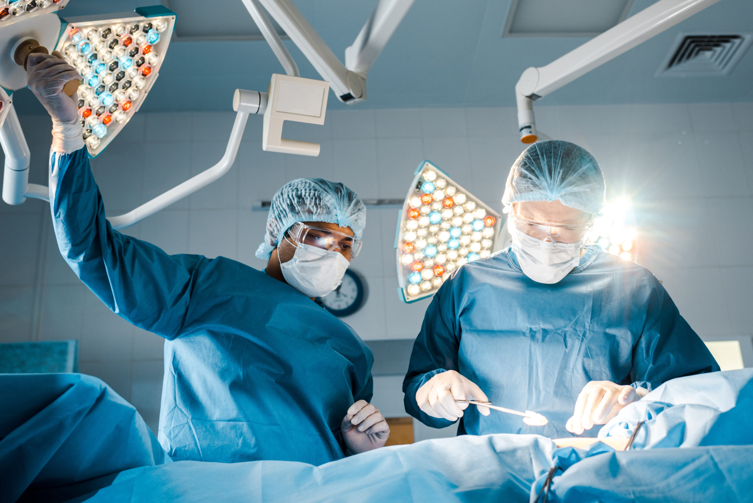 nurse and surgeon in uniforms and medical masks talking in operating ...